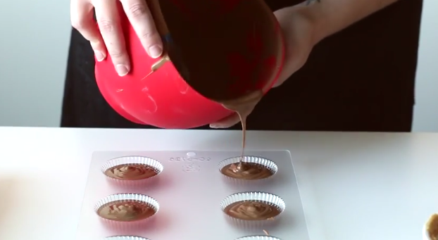 Pouring chocolate into a peanut butter mold