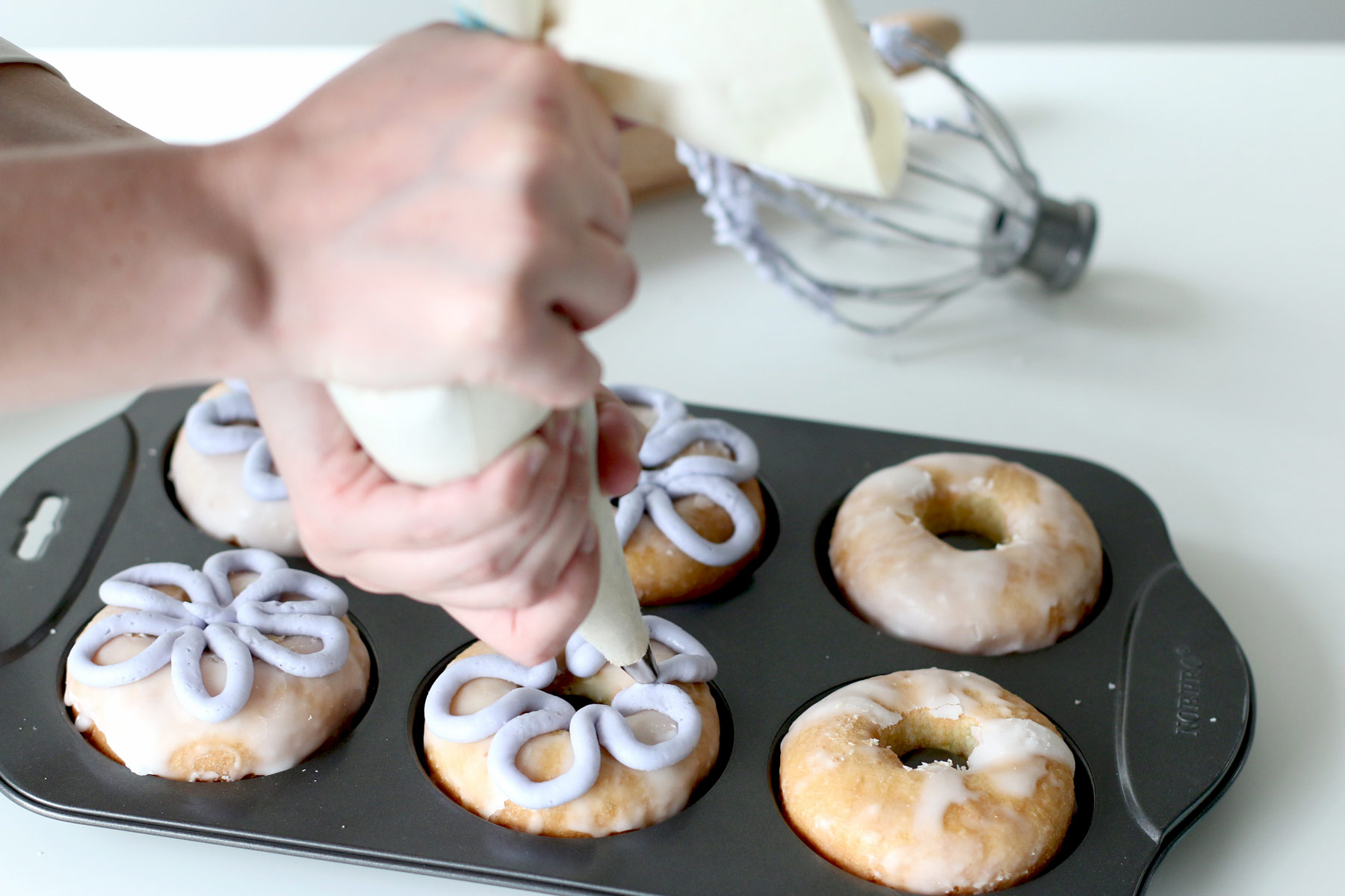 Piping onto homemade baked cake donuts