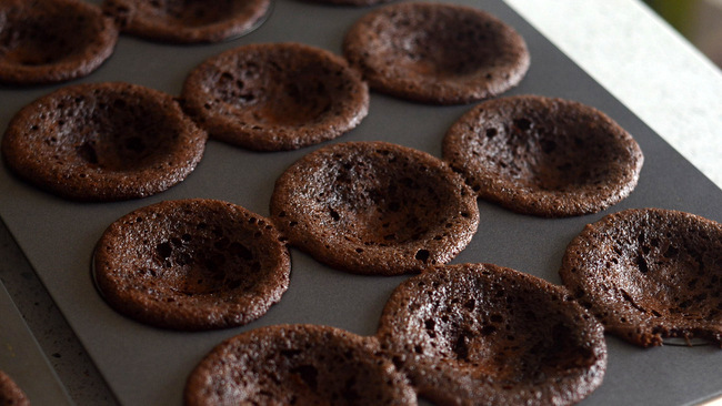 pan of 12 chocolate cupcakes with sunken middles. This is part of a post about trouble shooting cakes. 