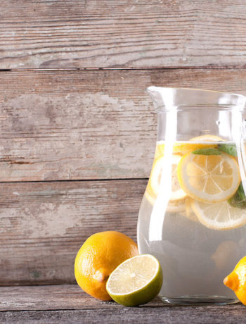 glass pitcher filled with Gygi lemon water, ice, and sliced lemons