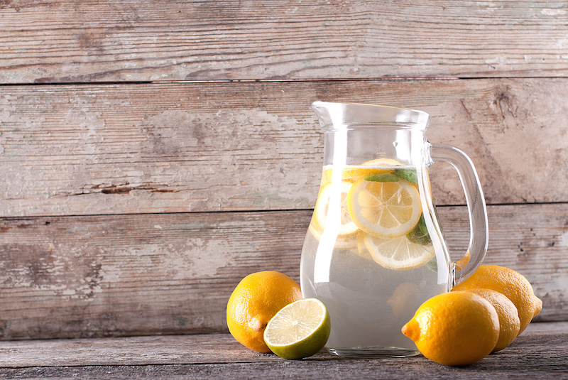 glass pitcher filled with Gygi lemon water, ice, and sliced lemons