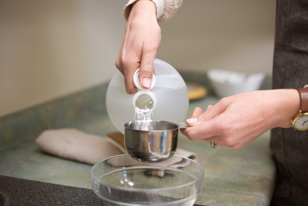 Vinegar being poured into a measuring cup