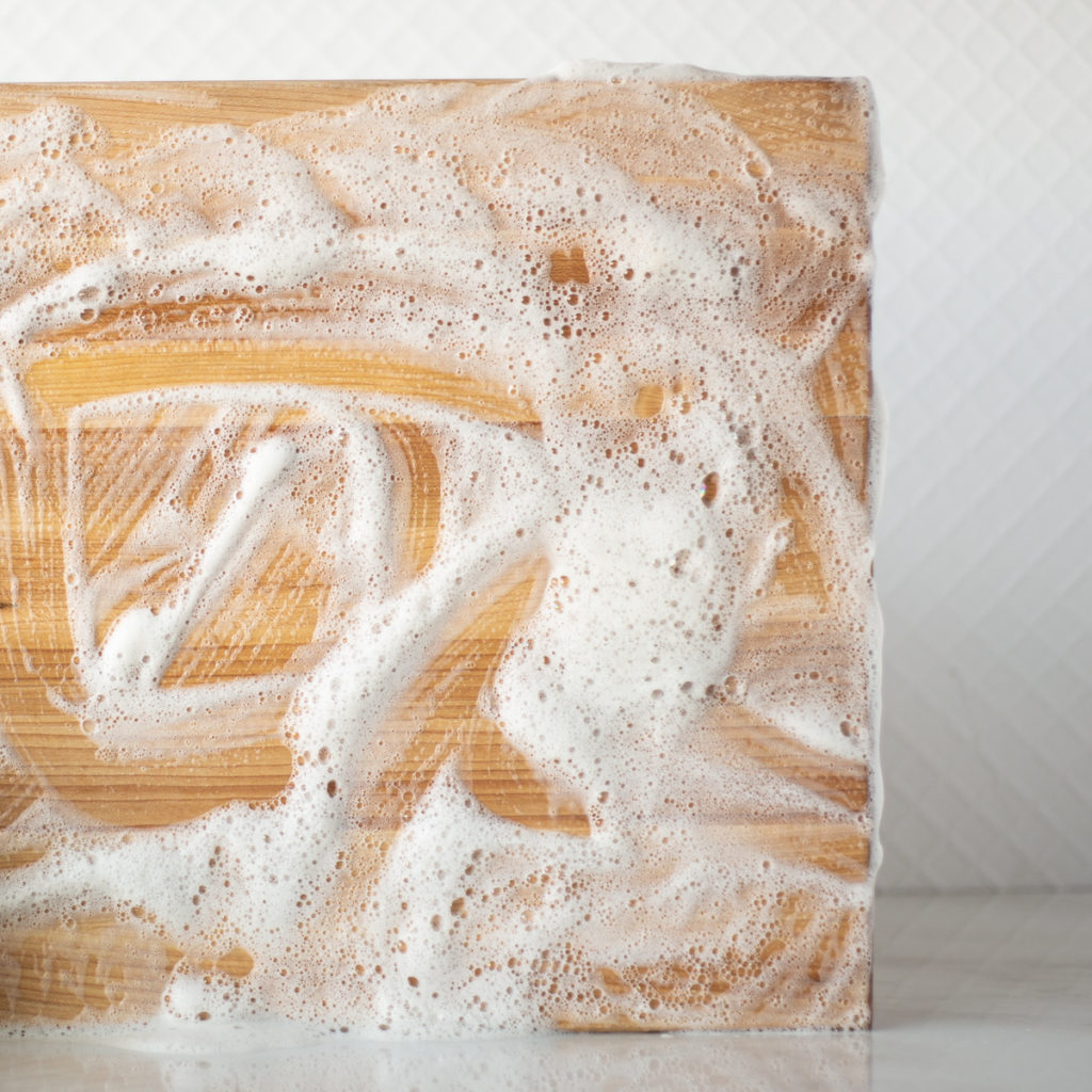 Wood cutting board covered in soap