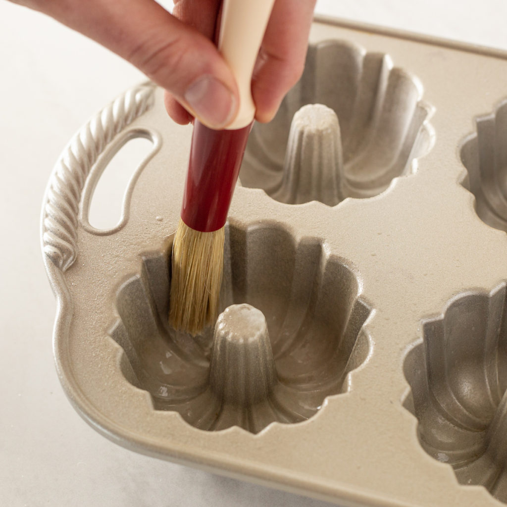 nonstick spray is brushed onto a cake pan