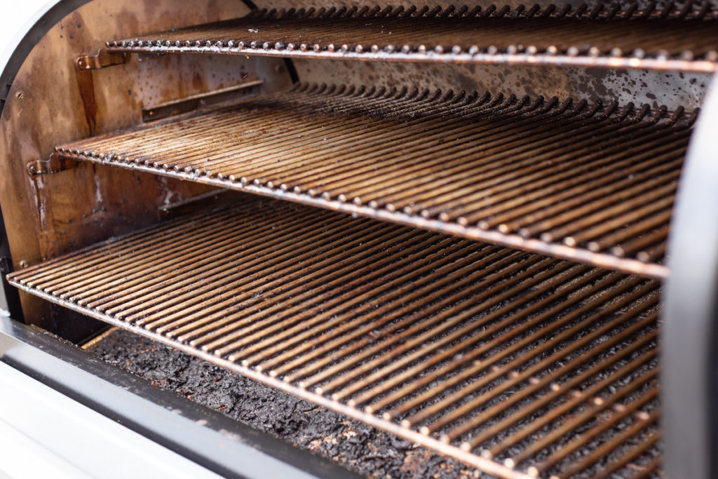 The interior of a pellet grill in need of cleaning