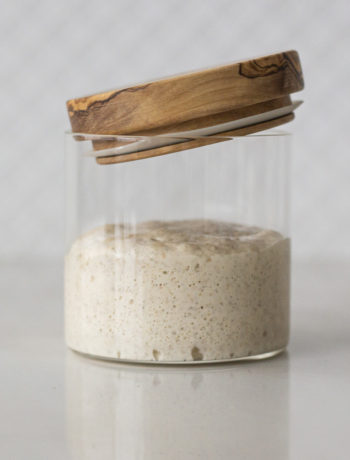 sourdough starter in a glass jar with loose fitting lid