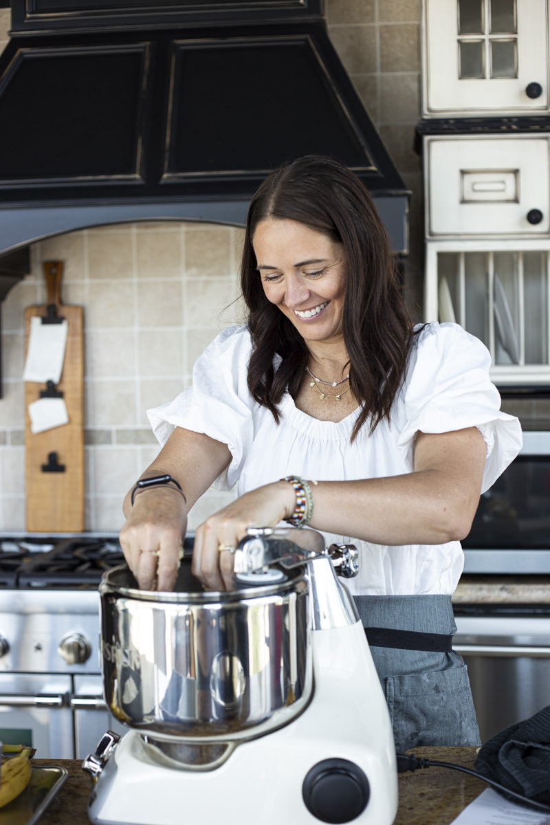 Heather smiling next to the Ankarsrum kitchen mixer