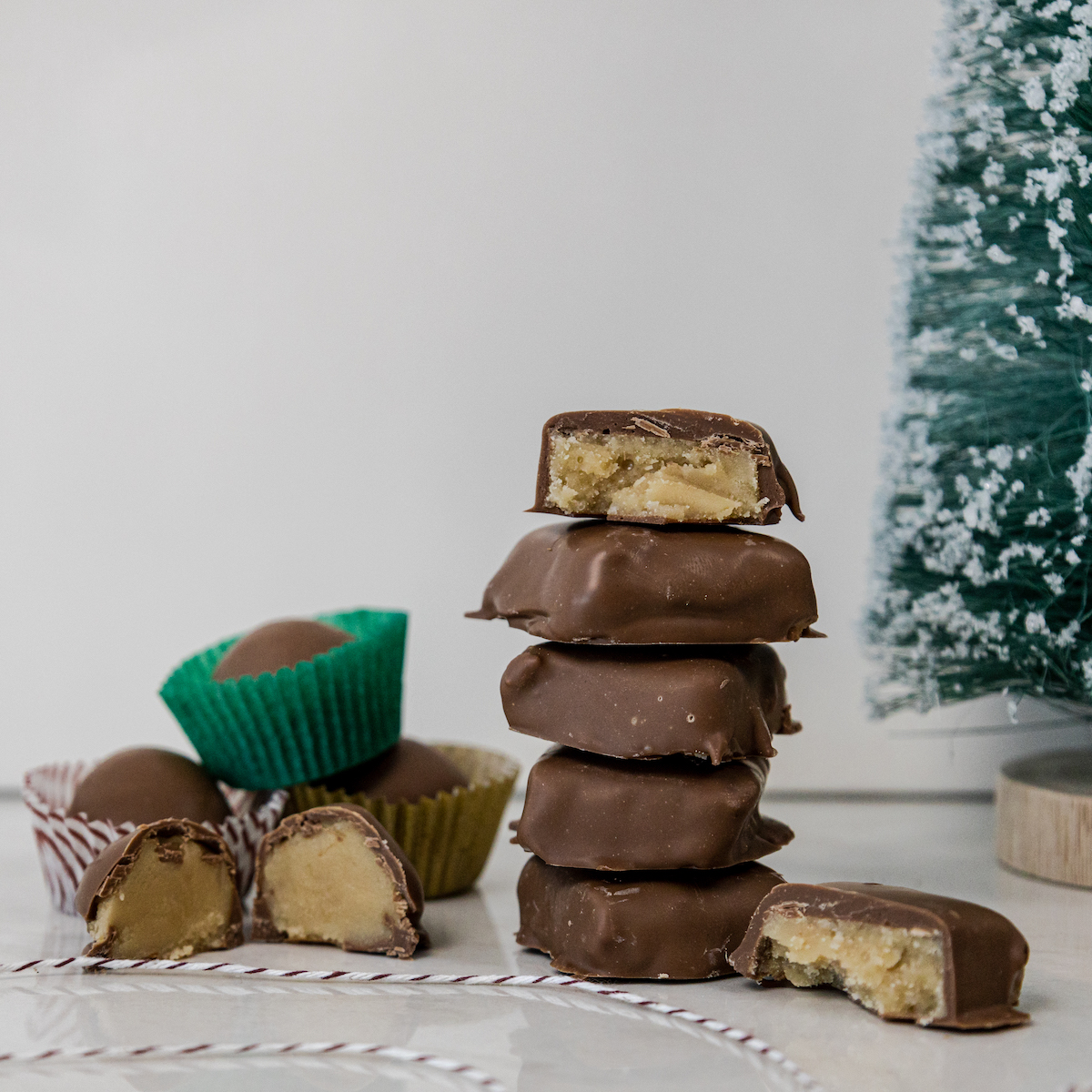 Homemade penuche that has been rolled and cut into squares, then dipped in chocolate. 