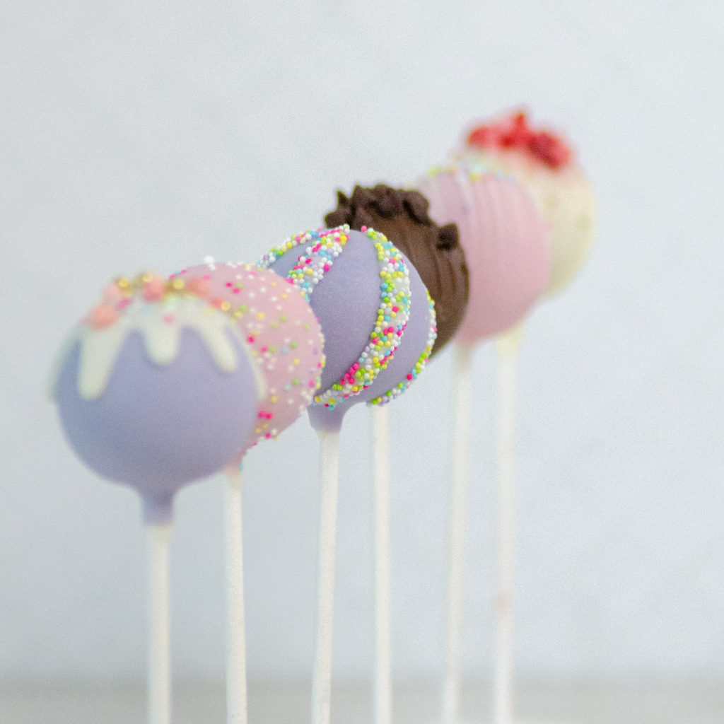 Row of different colored decorated cake pops