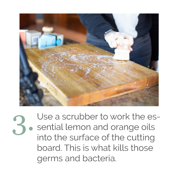 A scrubber is cleaning the cutting board